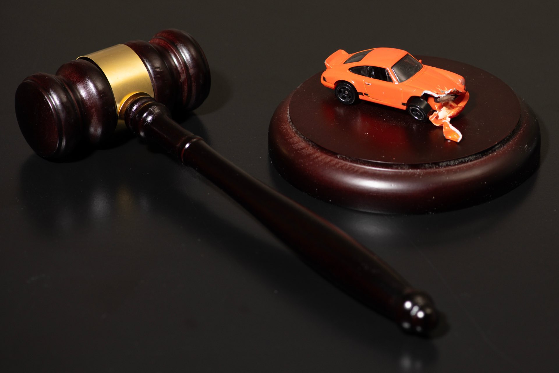 A gavel next to an orange toy car