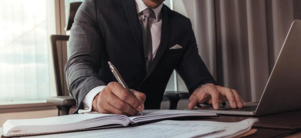Man in a suit writing notes | personal injury lawyer colorado | The Law Offices of Edward Smith LLC